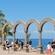 A structure with 4 arches at a cliff lookout, with tourists admiring the ocean